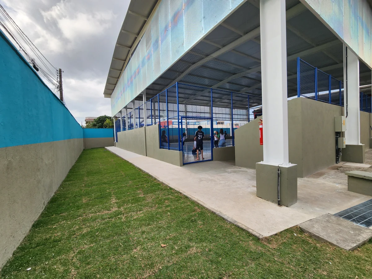 Lateral da quadra com muretas, alambrado e calçada