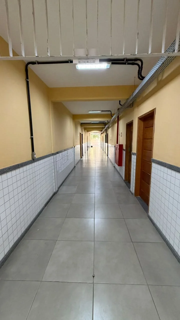 Corredor interno com acabamento padronizado e sinalização de segurança