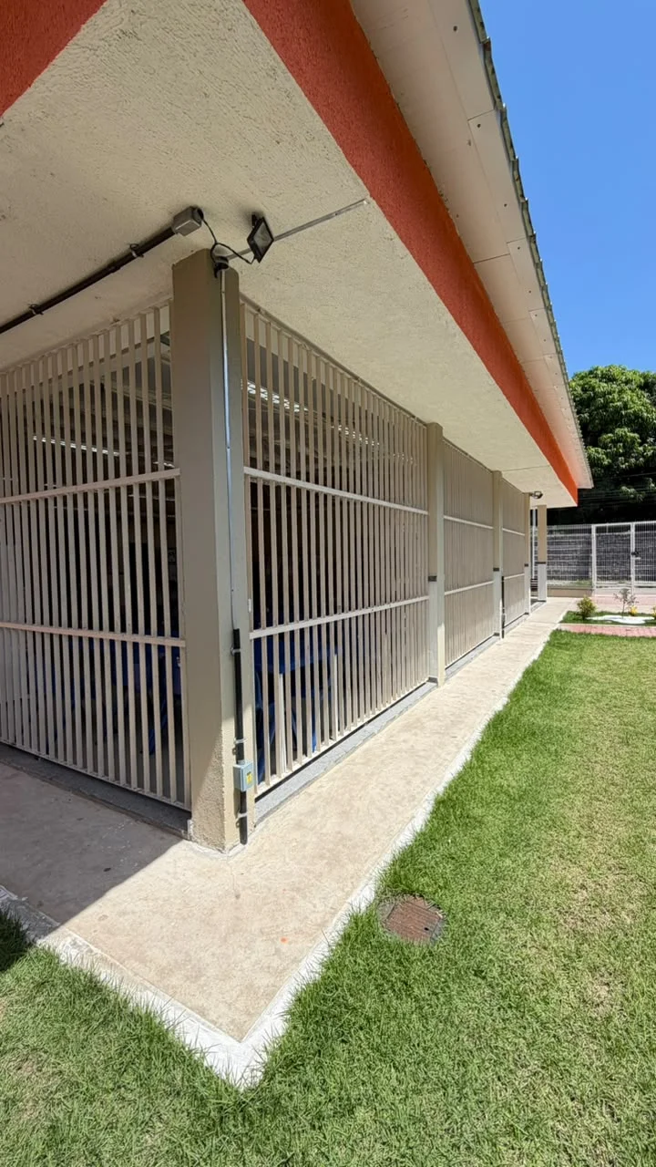 Fachada lateral com gradil metálico novo e jardim